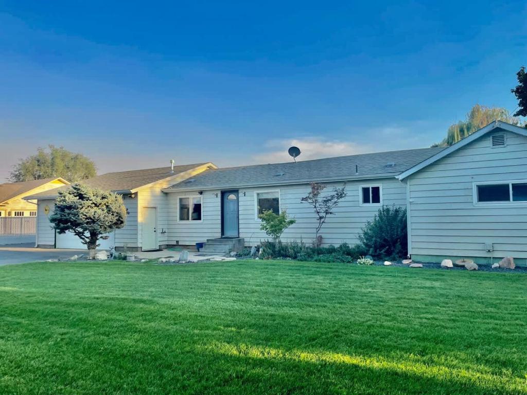 a house with a green lawn in front of it at Gravel Road Getaway in Hermiston