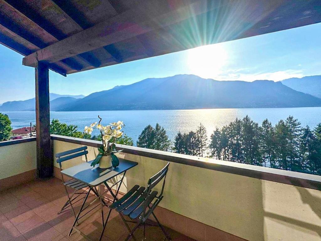 a balcony with a table and chairs and a view of the water at Maison Sophie Lake Como Vista Panoramica AC in Dorio