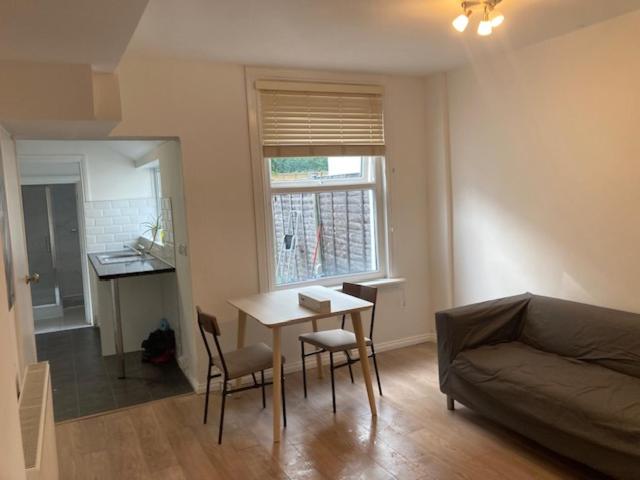 a living room with a couch and a table at Chestnut Villa in Epsom