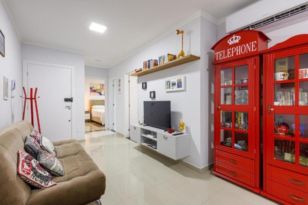 a living room with a red cabinet and a television at Little Britain no centro de Pomerode in Pomerode