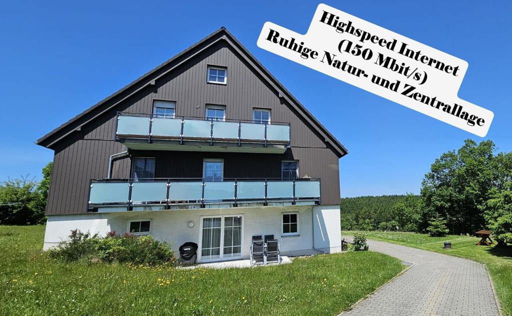 a large house on a hill with a sign at Bergidylle- Saniert und Hochwertig mit Massivholzmöbeln, Sonnenterrasse in der Natur, fußgängig ins Zentrum in Kurort Altenberg