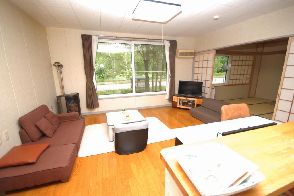 a living room with a couch and a table at 民宿やまのほ in Engaru