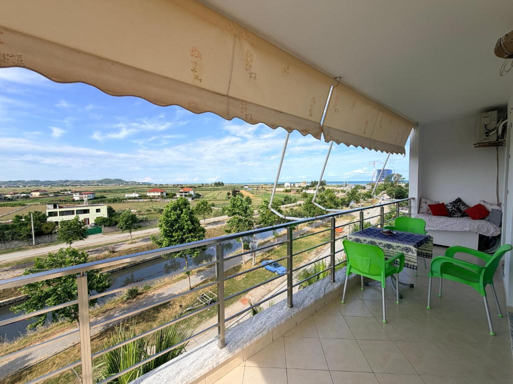 a balcony with a table and chairs and a view at Sunrise Apartment Qerret in Kavajë