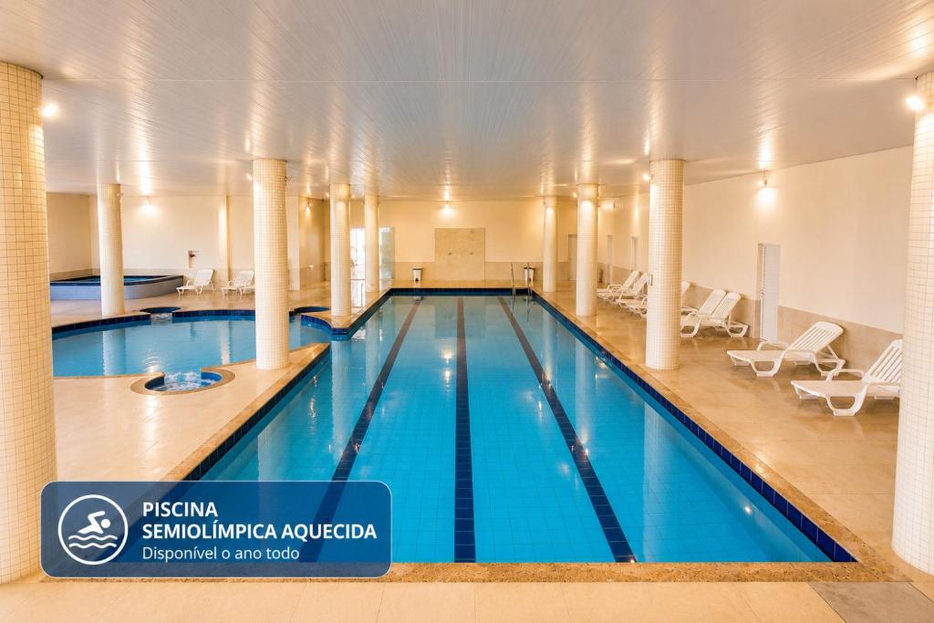 a large swimming pool in a building at THE - Tropicanas Hotel e Eventos in Florianópolis