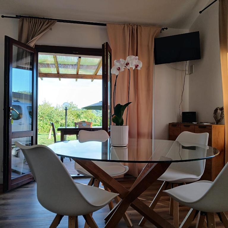 a dining room with a glass table and white chairs at Da Elio in Montacuto