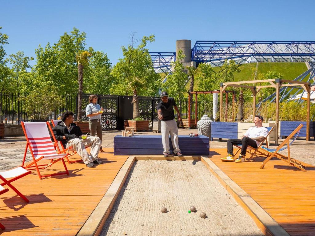 a group of people sitting on a deck playing a game at ibis Styles Paris Bercy in Paris