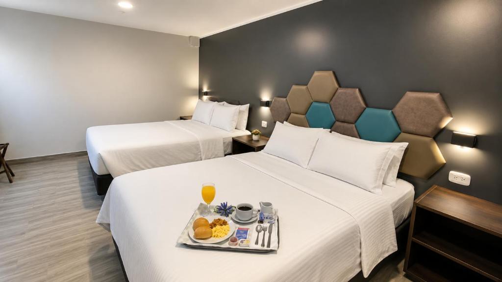two beds in a hotel room with a tray of food at Hospedaje Diamantes in Huacho