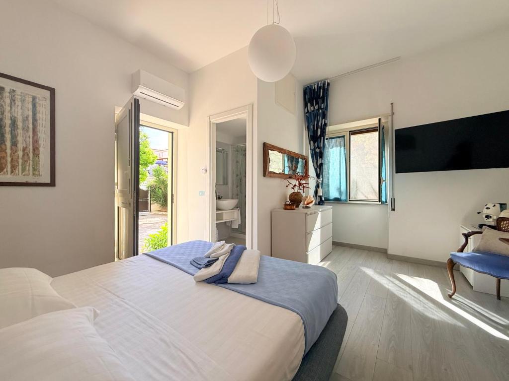 a bedroom with a large bed and a bathroom at B&B Edda Maison Centralissimo sul Lungomare con Posto Auto e Giardino Privato in Sperlonga