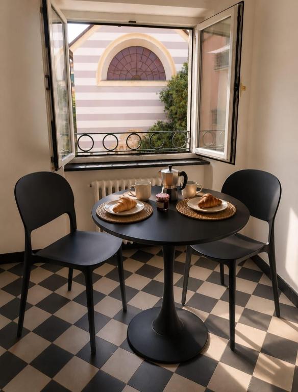 a table and chairs with food on it in a room with a window at Maison Cecilia in Rapallo