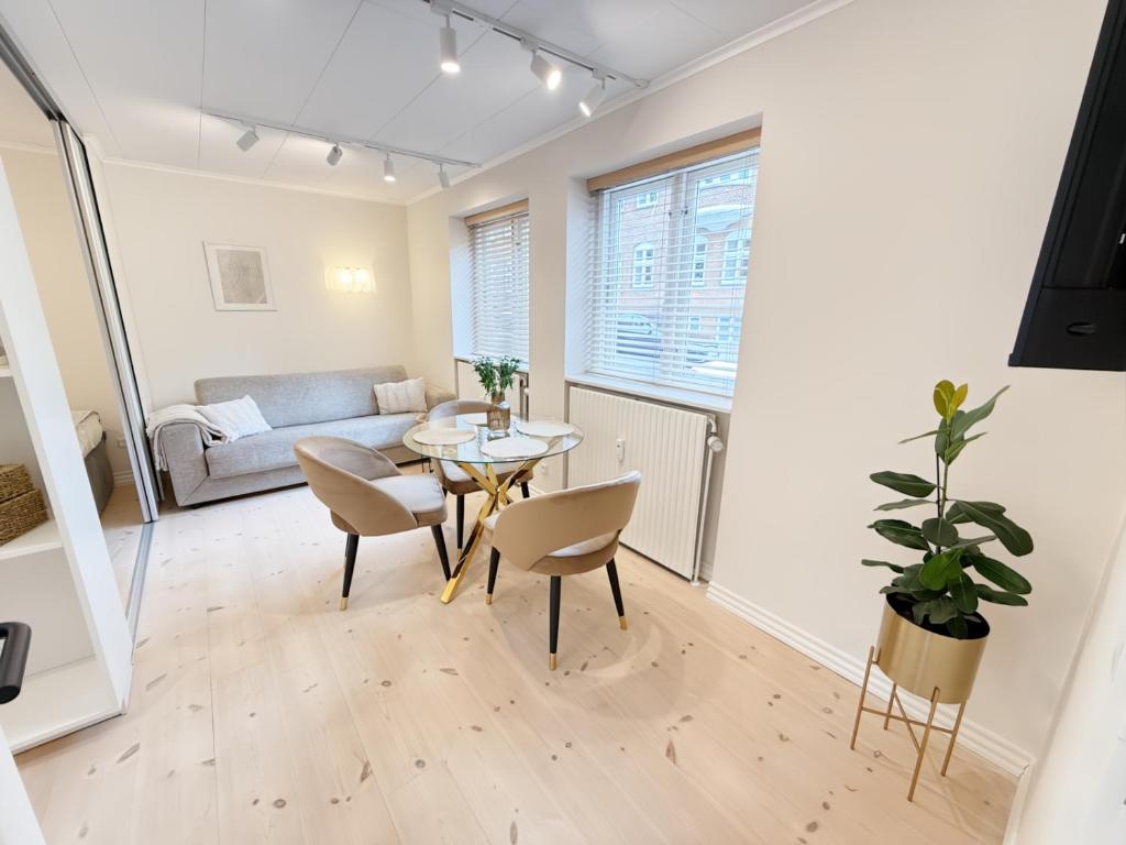 a living room with a table and chairs and a couch at Det Gamle Vaskeri - Historical Apartment in Horsens in Horsens