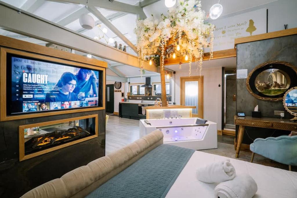 a large living room with a tv and a fireplace at Queen's Loft in Windermere