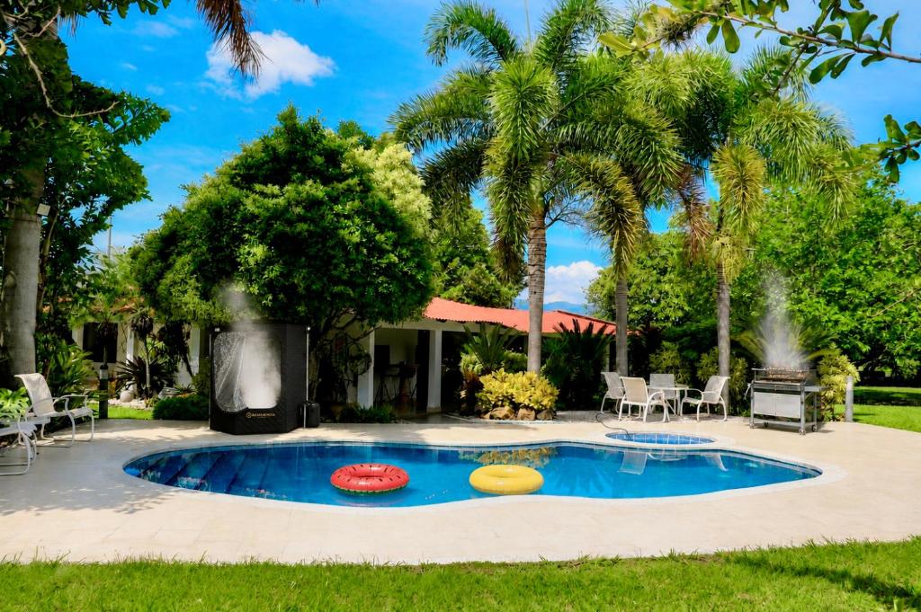 a pool with three frisbees in a yard at Villa de lujo a 20 mins Buga con Piscina privada, Jacuzzi y BBQ in Guacarí