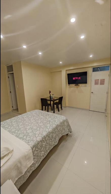 a bedroom with a bed and a table and a television at Casa Mi Perú in Urbanizacion Buenos Aires