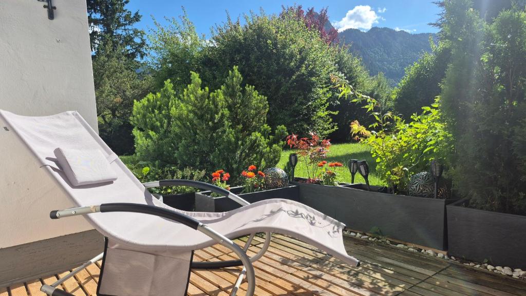 a white bench sitting on a deck with a garden at Ammergaufeeling mit einmaligem Bergblick, Terrasse, Nähe zur Nato Schule in Oberammergau