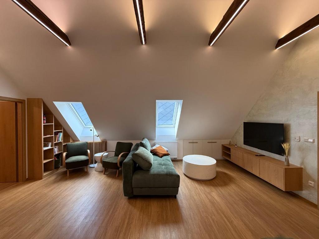 a living room with a couch and a tv at Apartmány u čalouníků in Litomyšl