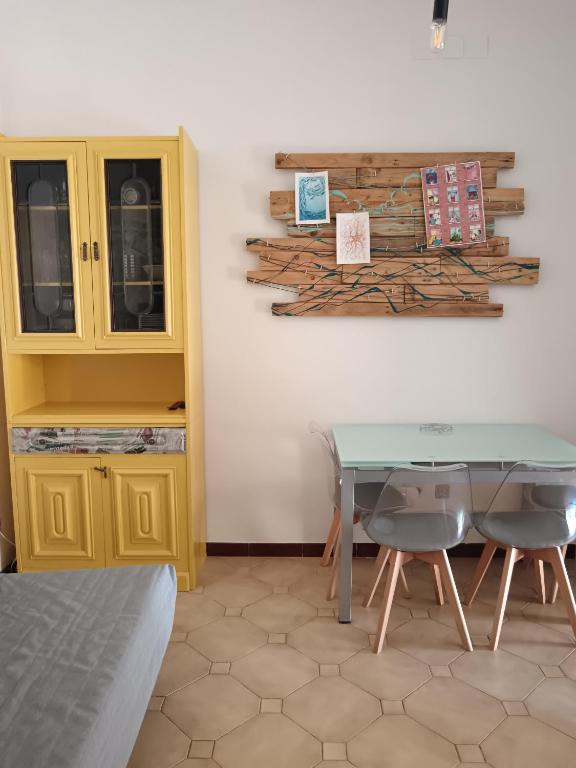 a room with a table and two chairs and a cabinet at Casa Cavour 15 in Porto Santo Stefano