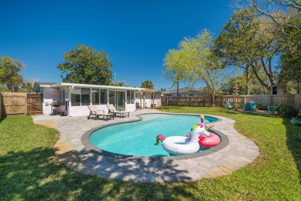 a swimming pool with two swans in a yard at Teal We Meet Again - Team Joseph Ellen in Jacksonville Beach