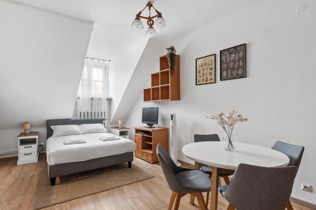 a bedroom with a bed and a table and chairs at Lublin Old Town Studio by BookingHost in Lublin