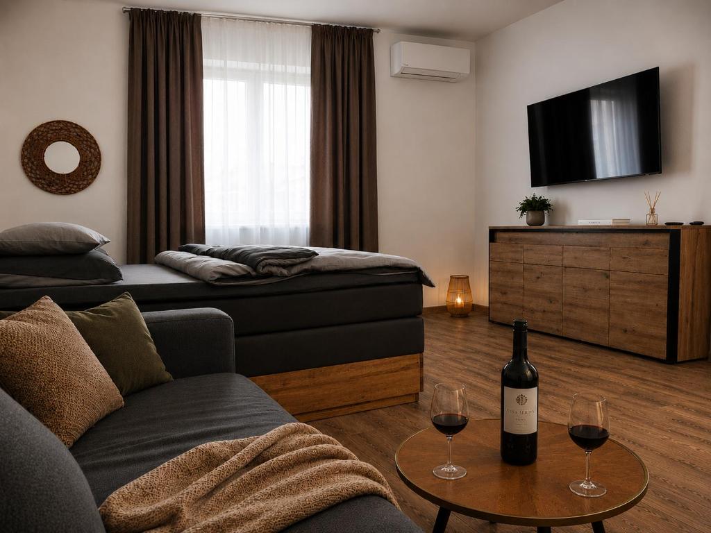 a living room with a couch and two glasses of wine at Apartmán u Fary-Harmony in Adršpach