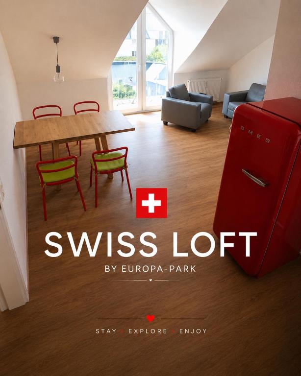 a living room with a red refrigerator and a table at SWISS LOFT by Europa-Park - EP Ticket Garantie in Rust