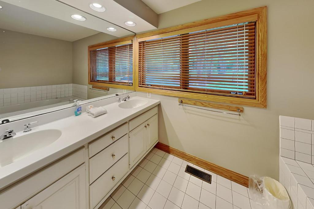 a bathroom with two sinks and a window at Johnny Appleseed in Oakland