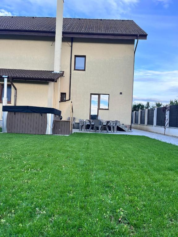 a house with a yard with green grass in front of it at Casa Bella in Sînpetru
