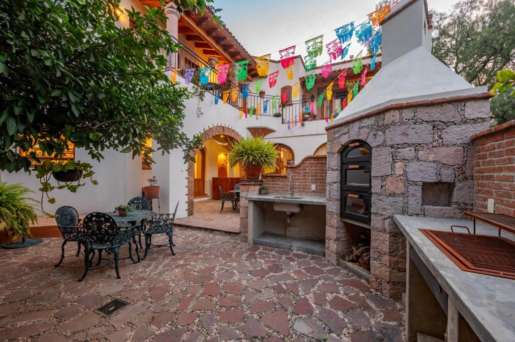 an outdoor patio with a table and chairs and a fireplace at La Sagrada in Guanajuato