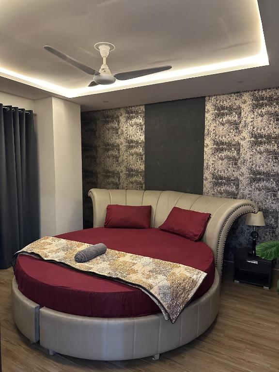 a bedroom with a large bed with red pillows at The crimson round bed luxe suite in Rawalpindi