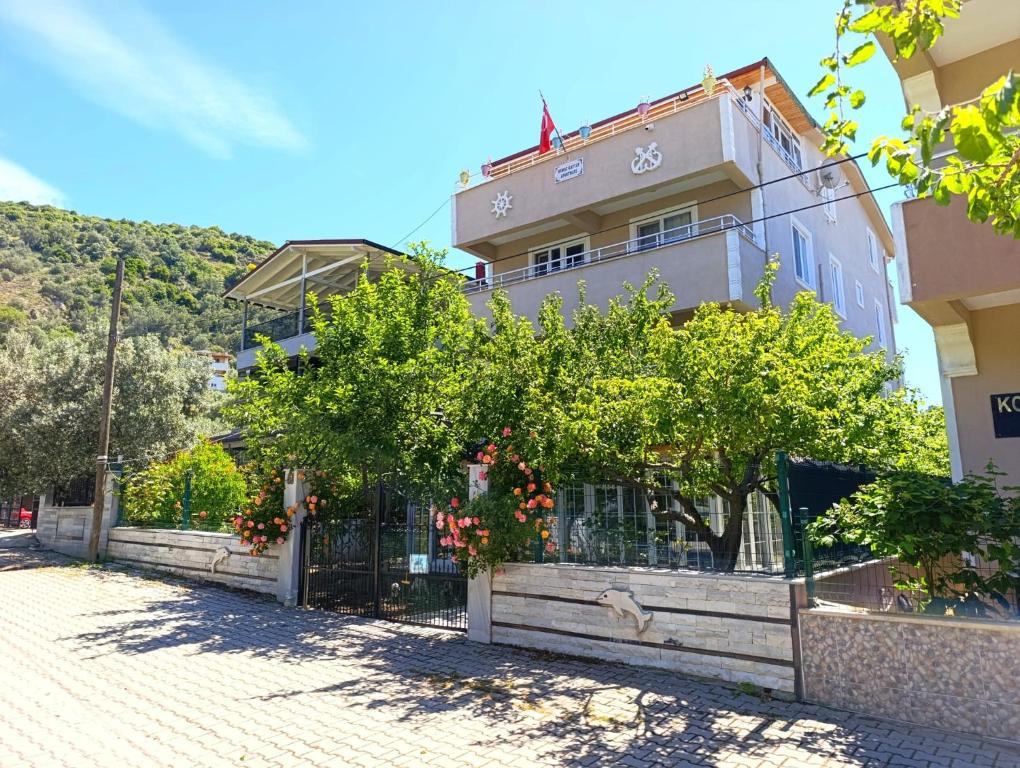 a building with a fence and trees in front of it at Murat Kaptan Apt in Gündoğdu