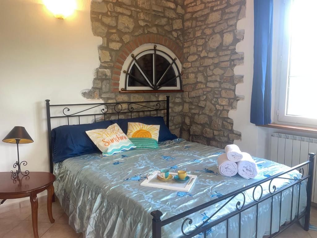 a bedroom with a bed with a stone wall at Giulieda in SUNSHINE giardino privato in Sanfatucchio