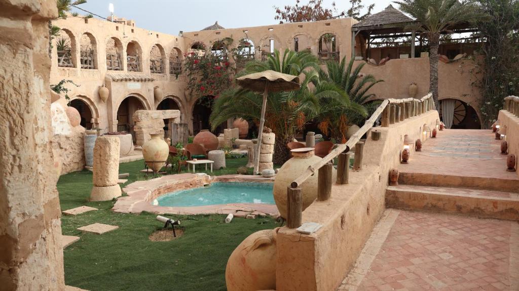 a courtyard with a swimming pool in a building at Tenasbook Jnen Rayhane in Midoun