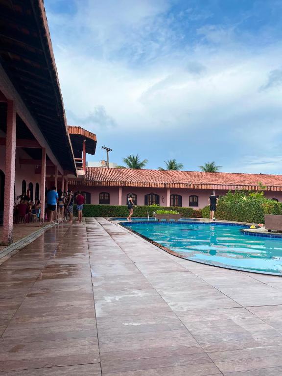 a swimming pool in front of a building at Pousada Caranã in Salinópolis