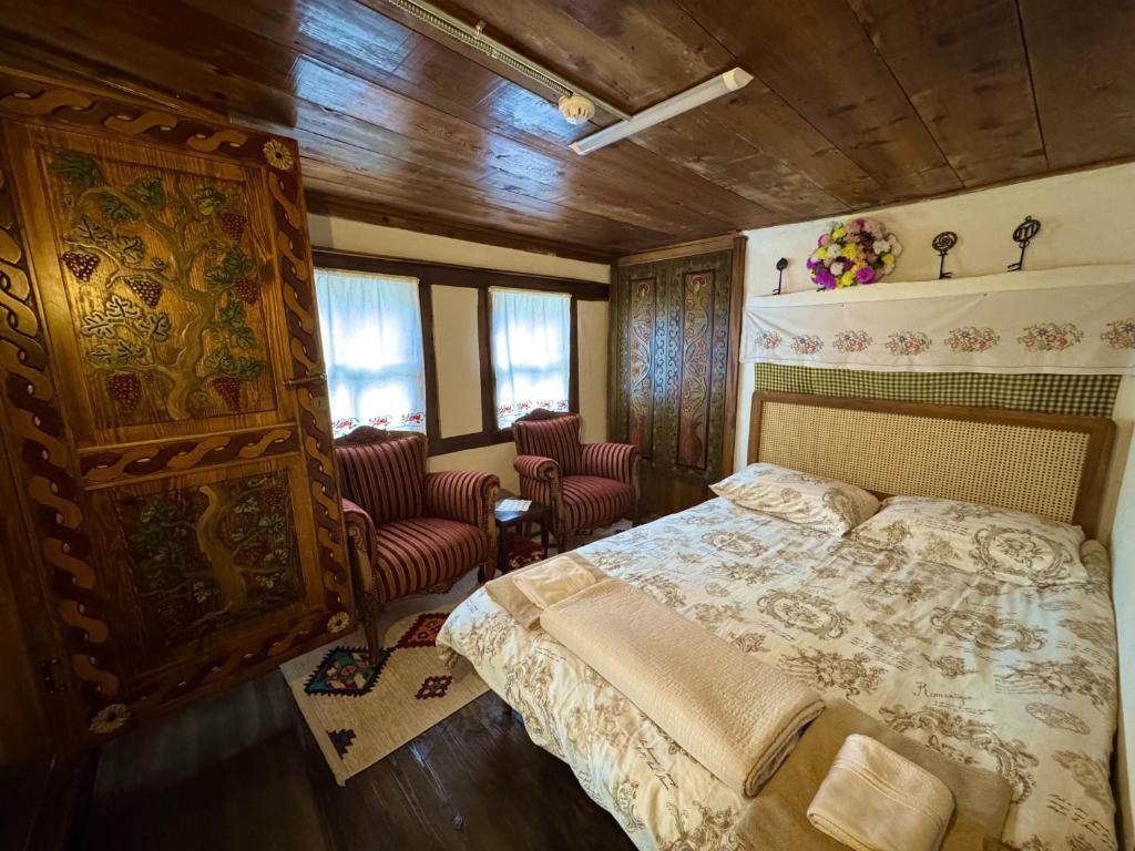 a bedroom with a bed and two chairs at Geyikli Konak in Mudurnu