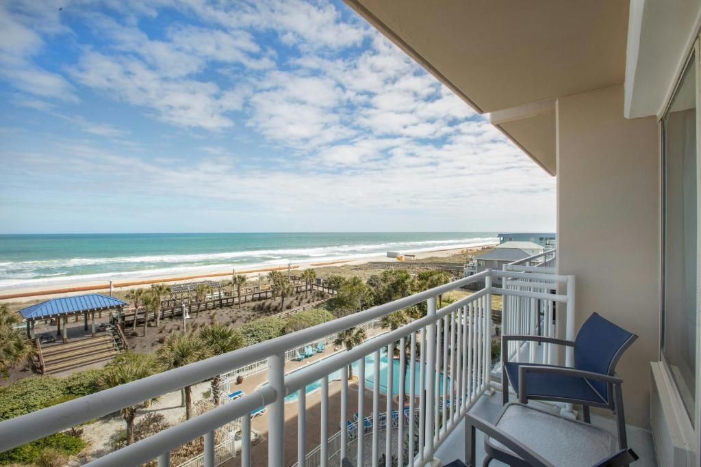 a balcony with a view of the beach and ocean at Courtyard by Marriott Carolina Beach Oceanfront in Carolina Beach