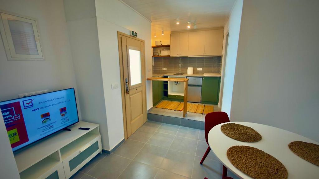 a kitchen with a table and a television in a room at Amerissas studios 4 in Skiros