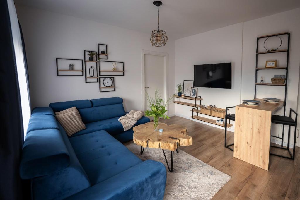a living room with a blue couch and a table at Modern Studio Apartment in Žepče