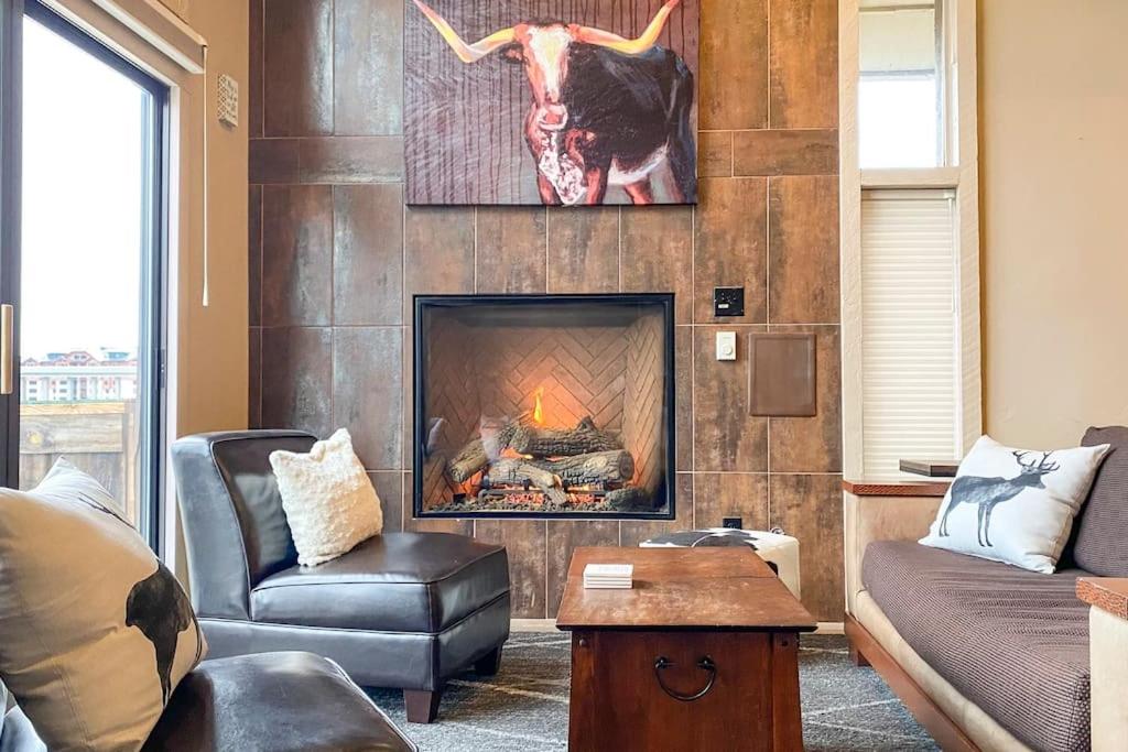 a living room with a fireplace with a cow on the wall at Slopeside Chalet in Steamboat Springs
