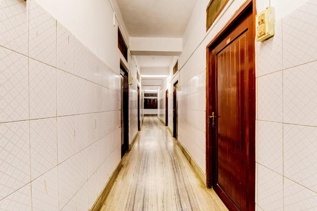 a hallway with a wooden door and a wooden floor at SPOT ON Durba 2 in Tezpur