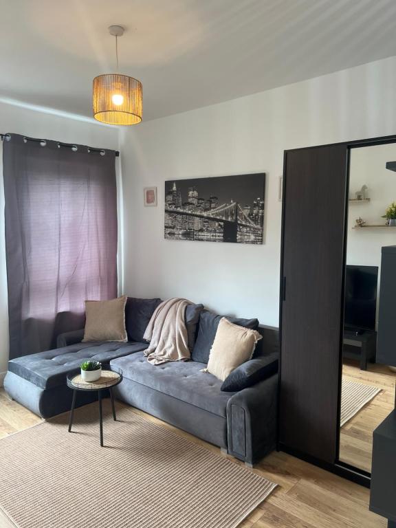 a living room with a blue couch and a table at Stadium Solution Flat in London