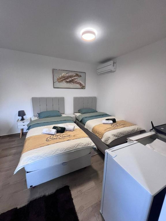 a room with two beds and a desk with a computer at Apartmani San Snova in Kotor-Varoš
