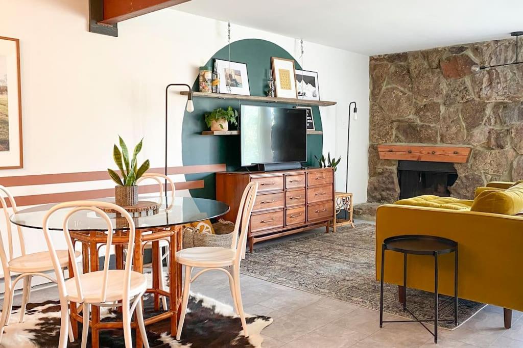 a living room with a table and a tv at Sunset Sanctuary in Steamboat Springs