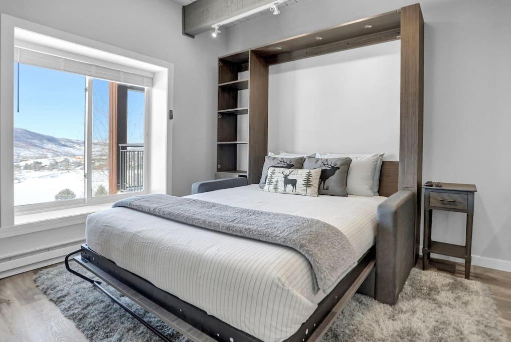 a bedroom with a large bed and a window at Gondola Heights Hideaway in Steamboat Springs