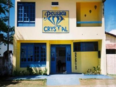 un edificio amarillo y azul con un cartel en él en Pousada Crystal, en Prado