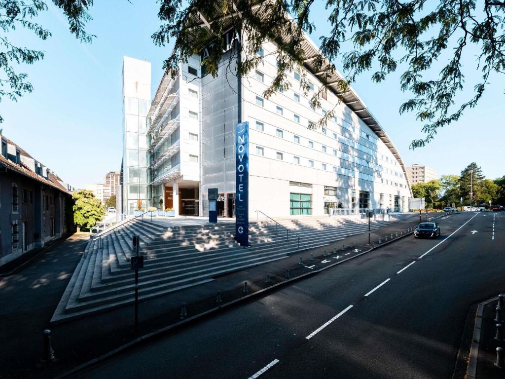 a large white building on the side of a street at Novotel Belfort Centre Atria in Belfort