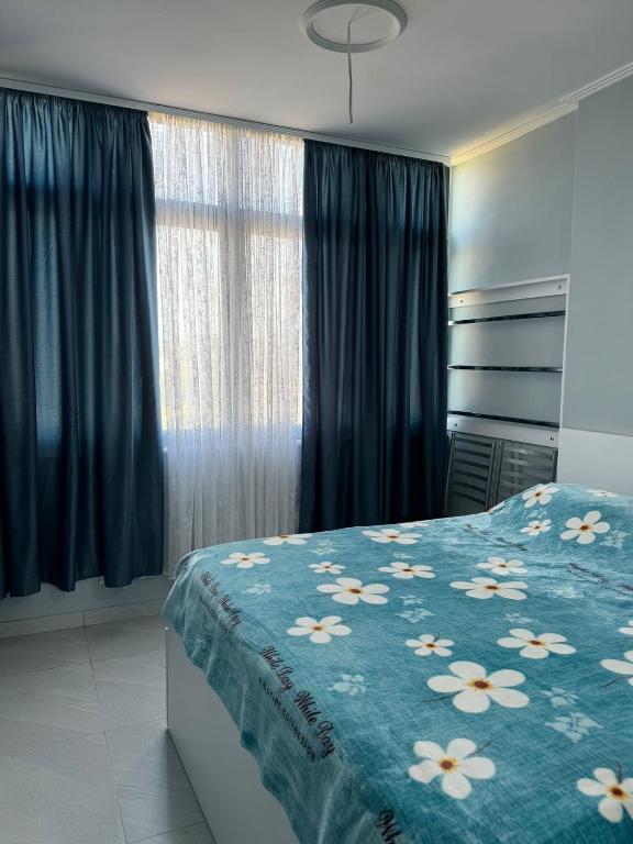 a bedroom with a bed with a blue blanket with flowers at Apartament M&L in Golem