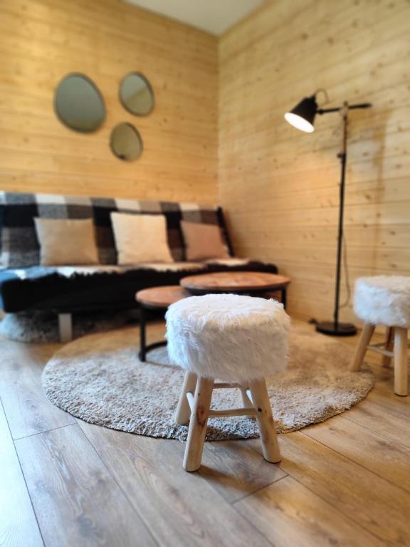 a living room with a couch and two stools at L'Esprit Boisé in Ustou
