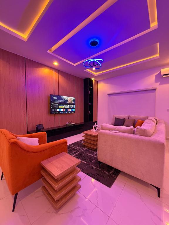a living room with a couch and a tv at Luxury 3 Bedroom Duplex Service Aparment in Abuja in Abuja