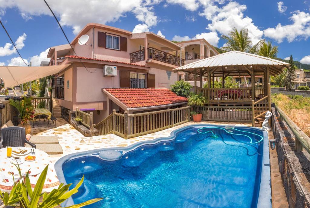 a house with a swimming pool in front of a house at Sunset Villa in La Gaulette