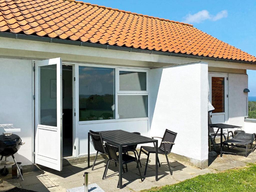 a table and chairs in front of a house at Modern Loft with Sea View in Allinge