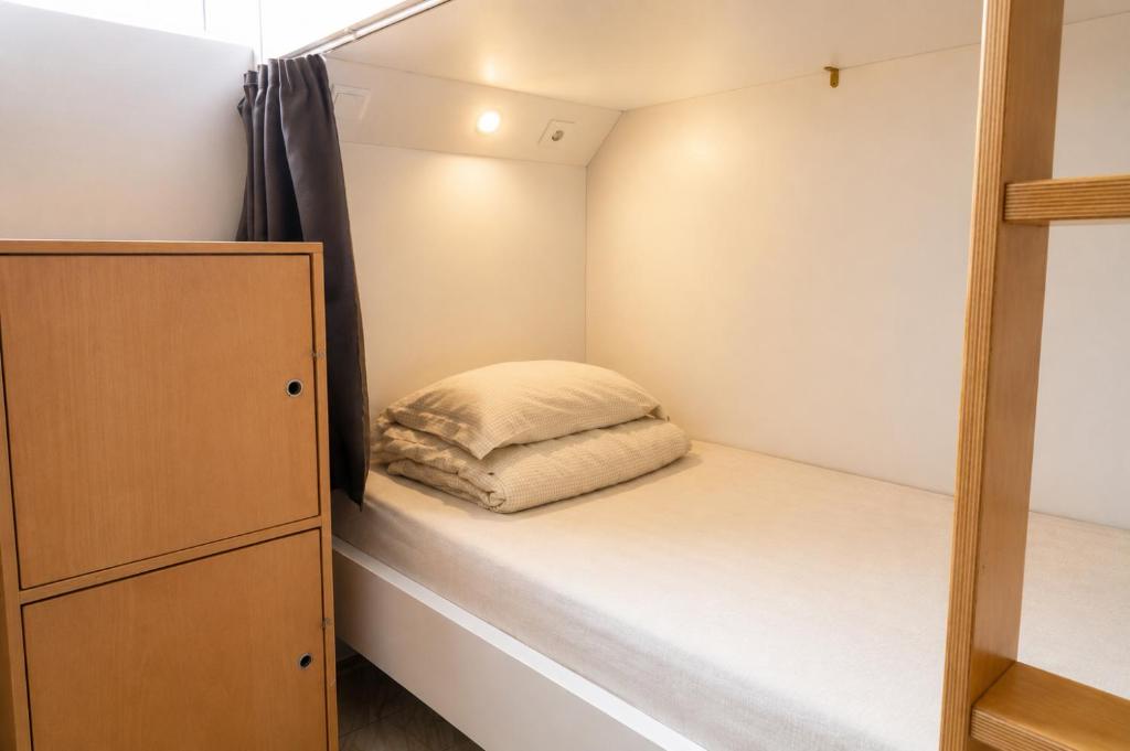 ein kleines Schlafzimmer mit einem Bett und einem Schrank in der Unterkunft Arca Nova Hostel - Caminha in Caminha